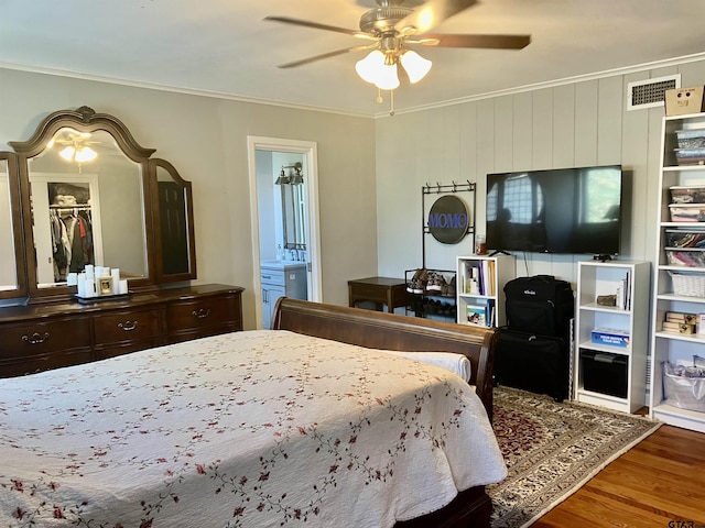 bedroom with ensuite bathroom, crown molding, hardwood / wood-style floors, and ceiling fan