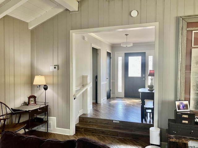 foyer featuring ornamental molding, dark hardwood / wood-style floors, lofted ceiling with beams, and wood walls