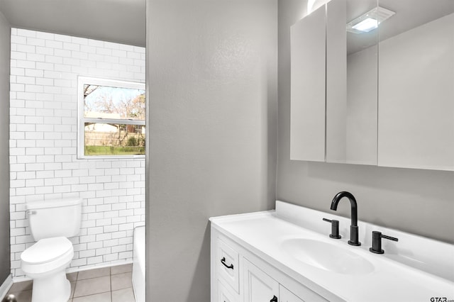 bathroom featuring tile walls, toilet, vanity, and tile patterned flooring