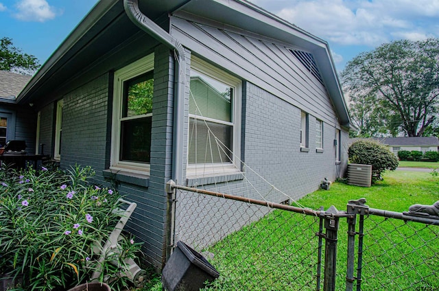 view of property exterior with central AC unit and a lawn