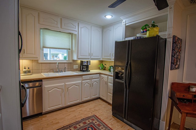 kitchen with light hardwood / wood-style floors, sink, stainless steel dishwasher, white cabinetry, and black refrigerator with ice dispenser