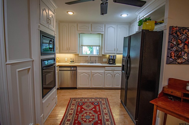 kitchen featuring white cabinetry, light hardwood / wood-style flooring, and black appliances