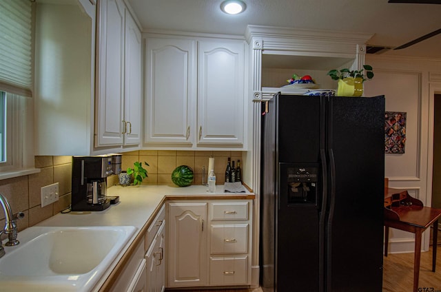 kitchen with wood-type flooring, white cabinets, decorative backsplash, sink, and black fridge with ice dispenser