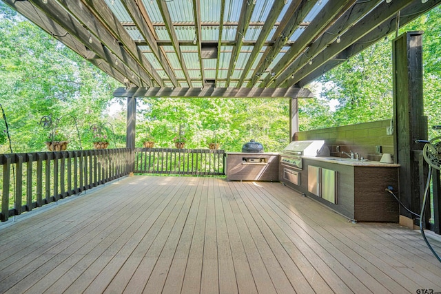 wooden terrace with an outdoor kitchen and a grill