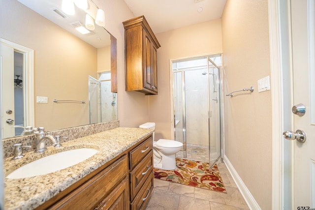 bathroom with tile patterned flooring, vanity, toilet, and walk in shower