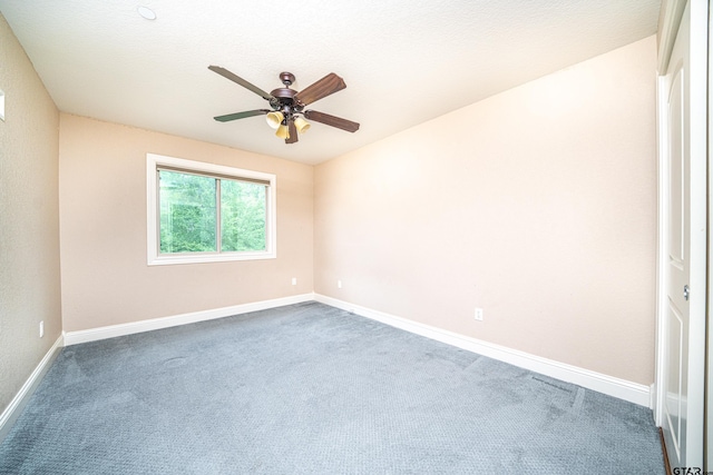 unfurnished room with ceiling fan and carpet