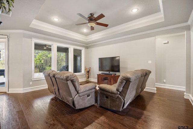 living room with dark wood finished floors, a tray ceiling, a ceiling fan, and baseboards