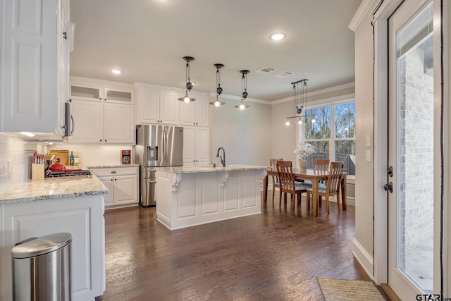 kitchen featuring stainless steel fridge, white cabinets, dark wood-type flooring, and ornamental molding