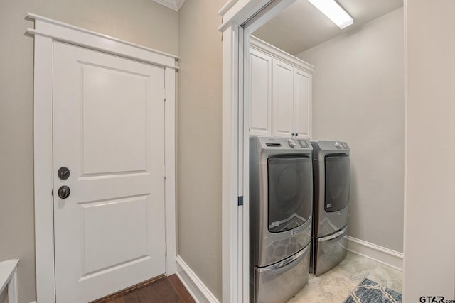 laundry room featuring cabinet space, baseboards, and separate washer and dryer