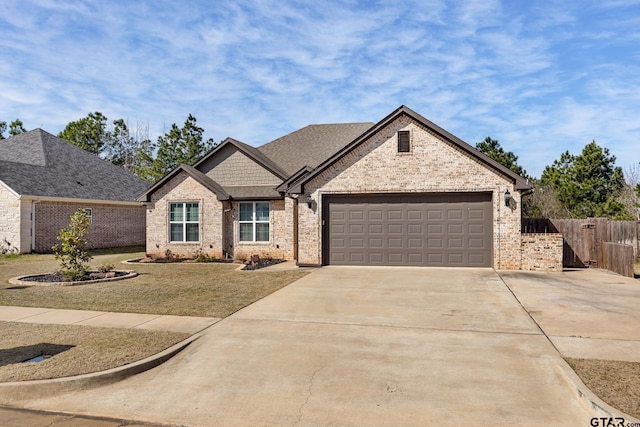 view of front facade featuring fence, concrete driveway, a front yard, a garage, and brick siding