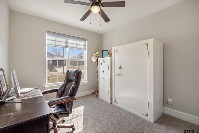 carpeted office featuring baseboards and a ceiling fan