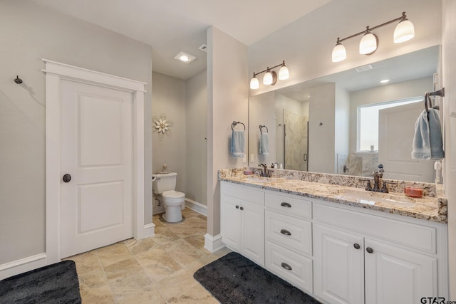 bathroom with double vanity, a stall shower, toilet, and a sink