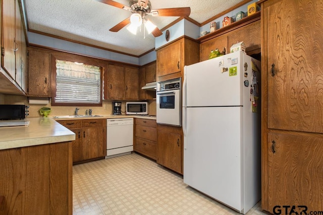 kitchen with white appliances, a textured ceiling, ceiling fan, and crown molding