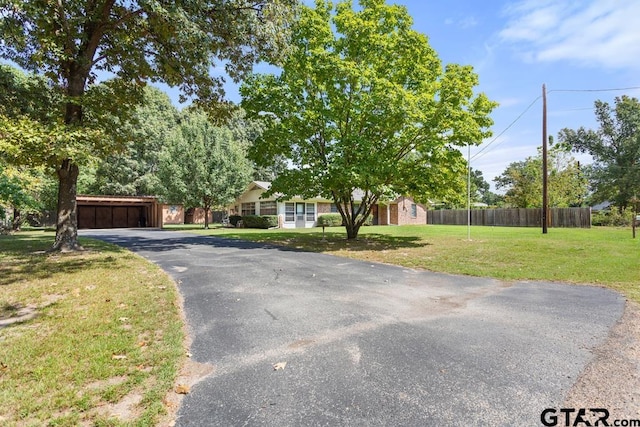 view of property hidden behind natural elements featuring a front yard