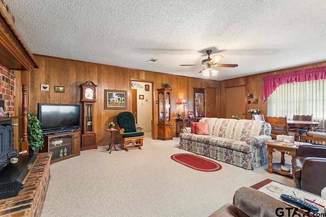 21187 Kristen Dr, Chandler, TX 75758 - living area featuring wooden walls, a ceiling fan, carpet, and a textured ceiling