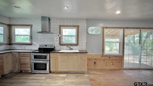 kitchen featuring decorative backsplash, light brown cabinetry, stainless steel electric stove, sink, and wall chimney range hood