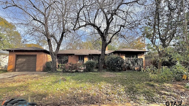 ranch-style home featuring a garage and a front lawn