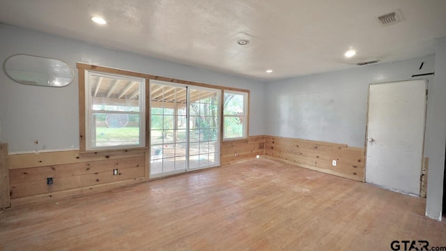 unfurnished room with wooden walls and wood-type flooring