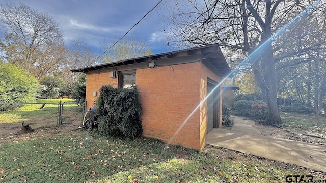 view of side of home with a lawn and an outbuilding