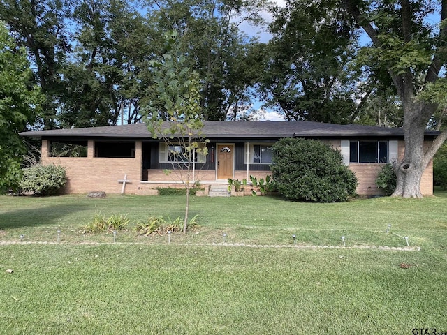 ranch-style home featuring brick siding and a front lawn