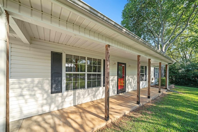 entrance to property with a yard and covered porch