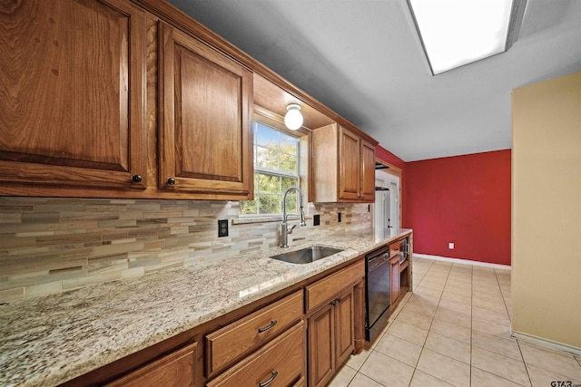 kitchen featuring light tile patterned flooring, black dishwasher, sink, backsplash, and light stone counters