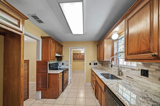 kitchen with light stone counters, black range with electric stovetop, sink, and light tile patterned floors