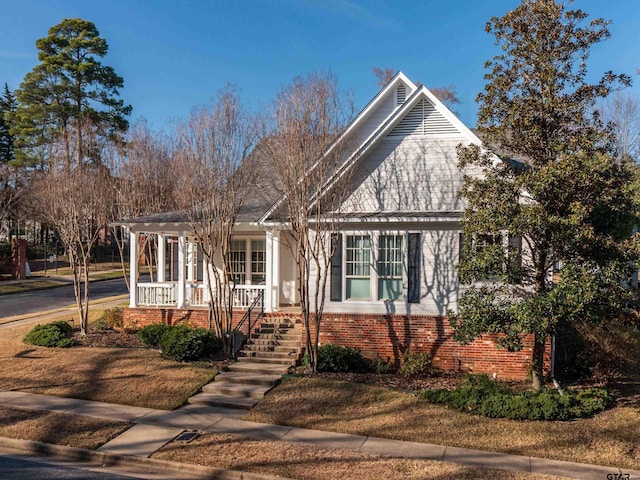 view of front of home with brick siding and a porch