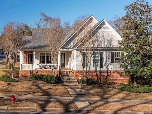 view of front of property featuring covered porch and brick siding