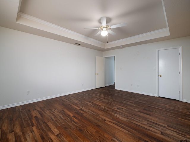 unfurnished room with ceiling fan, a raised ceiling, and dark hardwood / wood-style flooring