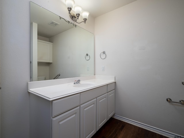 bathroom featuring wood-type flooring, toilet, and vanity