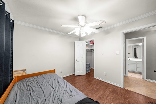 bedroom with hardwood / wood-style floors, ceiling fan, crown molding, a closet, and a spacious closet