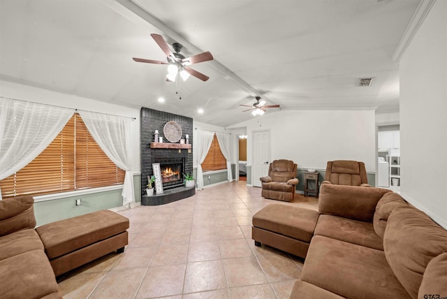 living room featuring ornamental molding, ceiling fan, light tile patterned floors, a fireplace, and vaulted ceiling