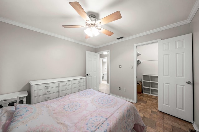 bedroom with ceiling fan, crown molding, a closet, and a walk in closet