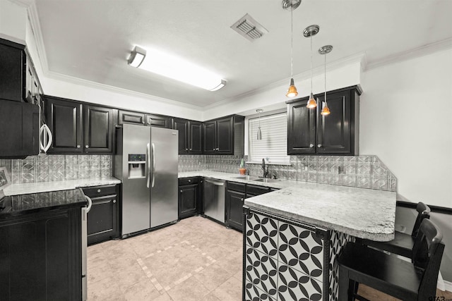 kitchen with kitchen peninsula, sink, crown molding, appliances with stainless steel finishes, and decorative light fixtures