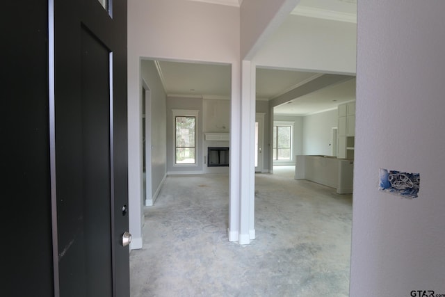 corridor with baseboards, concrete flooring, and crown molding