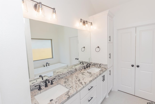 bathroom with a washtub, vanity, and vaulted ceiling