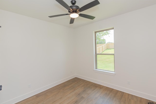 unfurnished room with wood-type flooring, a wealth of natural light, and ceiling fan