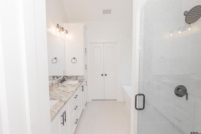 bathroom featuring a shower with shower door and vanity