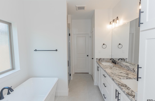 bathroom with a tub, tile patterned flooring, and vanity