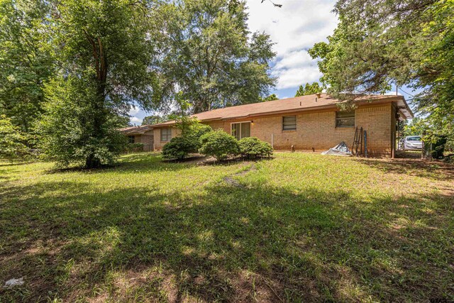 2114 Martin Luther King Blvd, Palestine, TX 75803 - rear view of house featuring a yard and brick siding
