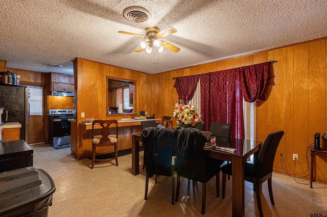 2114 Martin Luther King Blvd, Palestine, TX 75803 - dining area with a ceiling fan, wood walls, and a textured ceiling