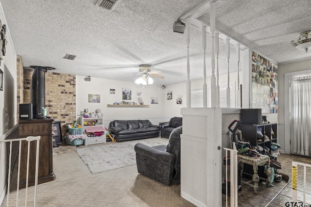 carpeted living room with a wealth of natural light, visible vents, and a textured ceiling