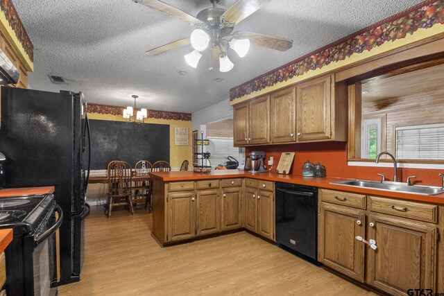 kitchen with black appliances, hanging light fixtures, sink, kitchen peninsula, and light hardwood / wood-style flooring