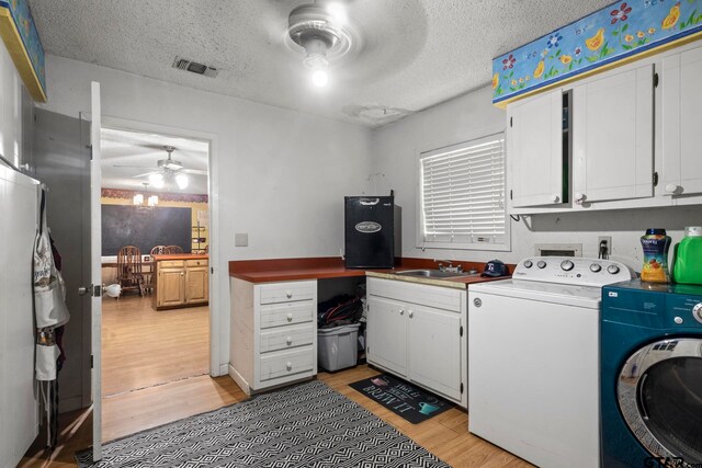 washroom featuring light wood-type flooring, cabinets, a textured ceiling, and ceiling fan