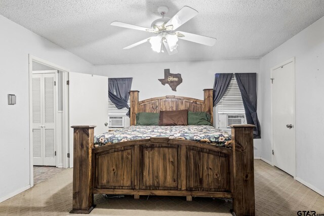 bedroom with a textured ceiling, light colored carpet, and ceiling fan