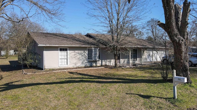 single story home featuring an attached garage and a front lawn