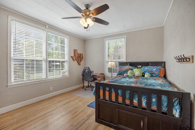 bedroom with crown molding, a textured wall, ceiling fan, light wood finished floors, and baseboards