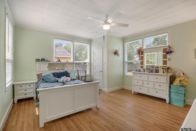 bedroom featuring baseboards, ornamental molding, ceiling fan, and light wood-style floors
