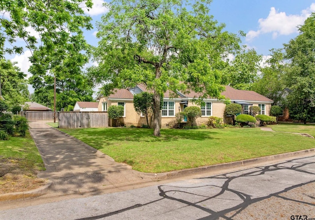 view of front of home featuring a garage, a gate, a front lawn, and fence